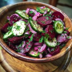 a wooden bowl filled with sliced up vegetables