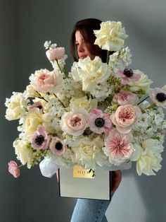 a woman holding a bouquet of white and pink flowers