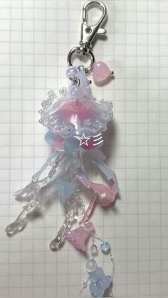 a key chain with several charms attached to it's sides and on top of a white surface