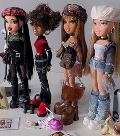 four dolls are standing next to each other