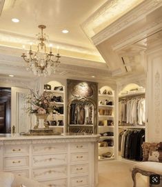 an elegant closet with chandelier and white furniture