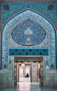 the entrance to an ornate building with blue and green tiles on it's walls