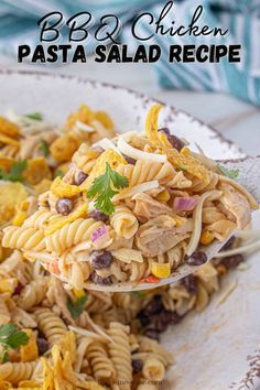 pasta salad with chicken and black olives on a white plate, ready to be eaten