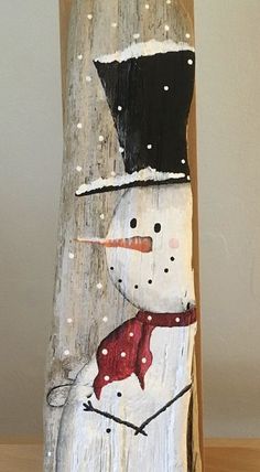 a snowman is painted on the side of a wooden pole with white and black dots