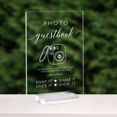 a clear acrylic sign with the words photo guestbook on it