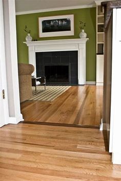 an empty living room with green walls and wood floors