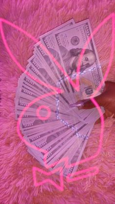 a pink teddy bear with lots of money in it's paws on top of a furry surface