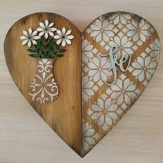 a wooden heart shaped box with flowers in it