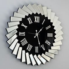 a black and white clock with roman numerals on it's face is shown