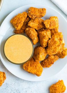 chicken nuggies and dipping sauce on a white plate