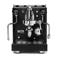 a black coffee machine sitting on top of a white table next to a clock and two gauges