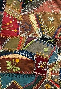 an old piece of cloth with many different colors and designs on it, including flowers