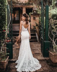 a woman in a wedding dress is walking down the steps to her house with an open door