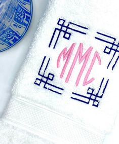 the monogrammed towel is next to a blue and white plate