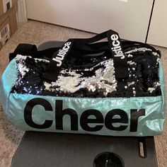 a bag that is sitting on top of a skateboard with the word cheer printed on it