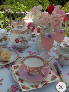 a table topped with plates and cups filled with flowers