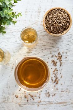 there are three cups of tea on the table next to each other and some plants