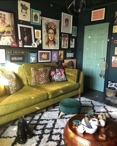 a living room filled with green couches and pictures on the wall next to a coffee table