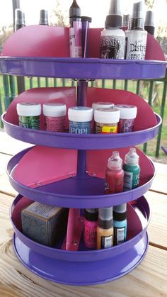 a purple three tiered shelf with paint bottles on it