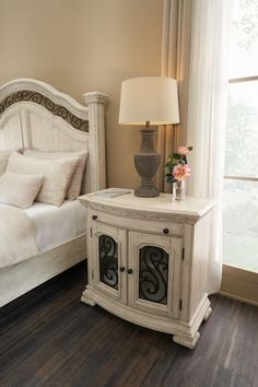 a white bed sitting next to a window in a bedroom