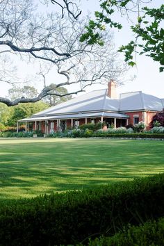 a large house sitting on top of a lush green field