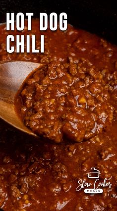 a wooden spoon full of chili with the words hot dog chili on it and in the background