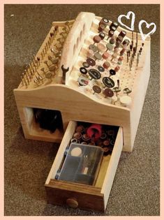 an open drawer with buttons and other items in it on the floor next to a carpeted area