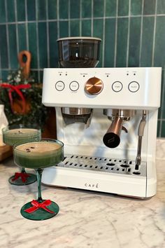 an espresso machine sitting on top of a counter next to a green cup