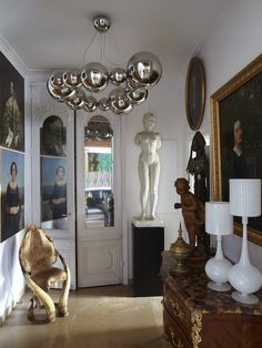 a living room filled with lots of furniture and art on the wall next to a doorway