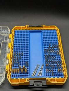 a plastic case filled with tools on top of a black table next to another box