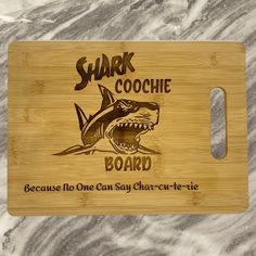 a wooden cutting board with an image of a shark and the words shark cooche board on it