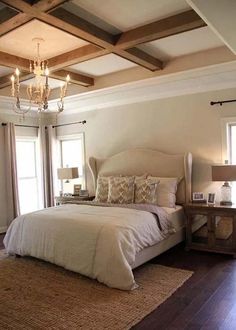 a bedroom with a large bed and chandelier