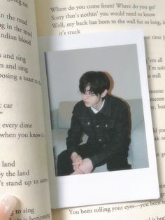 an open book with a photo of a young man sitting on top of a couch