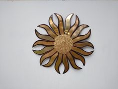 a metal sunflower on a white wall