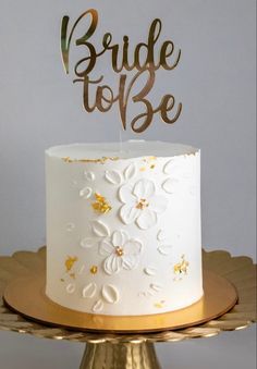 a white and gold wedding cake with the words bride to be on top