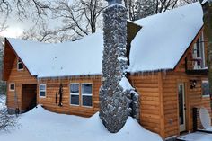 a log cabin with snow on the roof