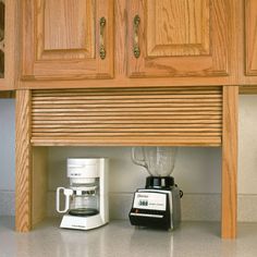 a blender and coffee maker under a kitchen cabinet