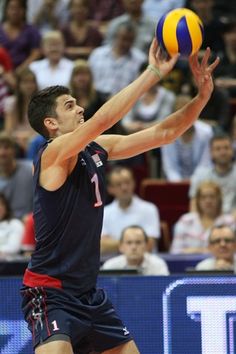 a man is reaching up to hit a volleyball