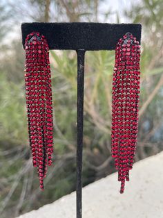 "These fun and stylish red crystal rhinestone earrings are a great statement piece! Size of earrings: .5\" Wide  and 3.5\" Long.  Color: red Base metal: black Style: pierced  More colors available upon request, just message us! Looking for a matching bracelet? https://www.etsy.com/listing/538148439/red-crystal-bracelet-large-crystal?ref=shop_home_active_33 Looking for the perfect pair of earrings for a special occasion. We specialize in custom work in fashion jewelry, pearls, and natural stones! Red Glamorous Chandelier Earrings For Evening, Glamorous Red Chandelier Earrings For Evening, Red Dangle Tassel Earrings For Party, Red Rhinestone Evening Earrings, Red Tassel Earrings For Party, Red Bling Earrings For Party, Red Rhinestone Crystal Earrings For Party, Red Crystal Rhinestone Earrings For Party, Red Crystal Earrings With Rhinestones For Evening