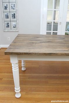 a wooden table sitting on top of a hard wood floor next to a white door