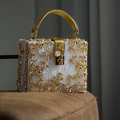 Discover the modern elegance of the Acrylic Box Handbag. This handbag redefines luxury with its box-shaped silhouette and gold-plated floral embellishments. Its sleek design and secure turn-up lock add a touch of sophistication. Perfect for a contemporary outfit, this vegan & cruelty-free handbag is a structural marvel that effortlessly blends style and function. Glitter Clutch Bag, Lug Bags, Women Boxing, Party Purse, Retro Mode, Vintage Purses, Crossbody Wallet, Branded Handbags, Small Shoulder Bag