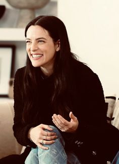 a woman sitting on top of a couch smiling