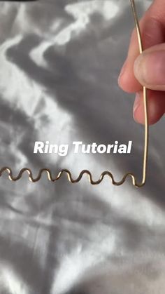 a hand holding a wire with the word ring tutor on it