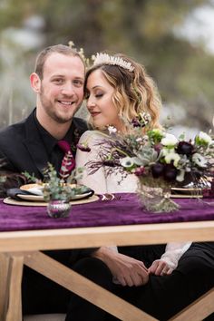 a man and woman sitting at a table with flowers