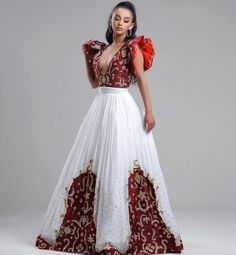 This stunning Habesha Kemis is a true masterpiece of Ethiopian fashion. The luxurious Menen fabric drapes elegantly over the body, creating a flattering silhouette. The upper portion of the dress features a Shimena top, which is a traditional Ethiopian blouse with a loose, flowing fit. The Shimena top adds a touch of elegance and sophistication to the dress. The lower portion of the dress features a Tilf design at the bottom, which is a traditional Ethiopian pattern that is often used in Habesha Red Sequined Dress For Navratri, Traditional Sequined Dresses For Navratri, Fitted Saree Gown For Traditional Ceremonies, Fitted Floor-length Bollywood Kaftan, Fitted Embellished Dress For Traditional Ceremonies, Fitted Kaftan For Traditional Ceremonies And Festivals, Anarkali Style Fitted Party Kaftan, Fitted Floor-length Kaftan With Traditional Patterns, White Cutdana Dress For Party