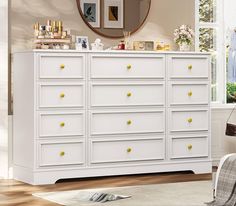 a white dresser with yellow knobs in a room