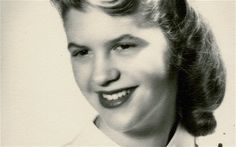 an old black and white photo of a woman smiling