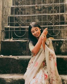 a woman sitting on the steps holding something in her hand