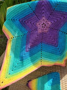 a crocheted blanket and pillow sitting on a chair outdoors in the sun,