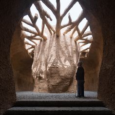 a person standing in an arch with stone walls